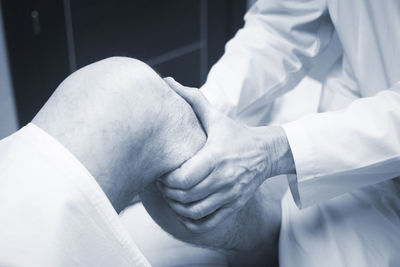 Midsection of doctor examining leg