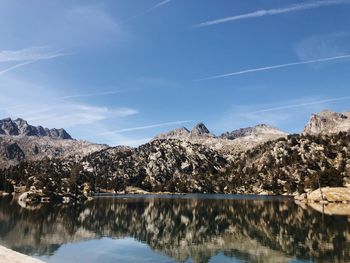 Scenic view of lake and mountains against blue sky