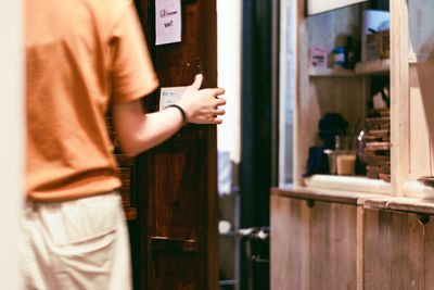 Midsection of man standing by door