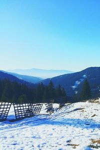 Scenic view of mountains against clear blue sky during winter