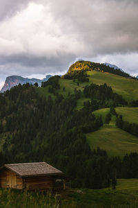 Cabin in the mountains with storm clouds at sunset