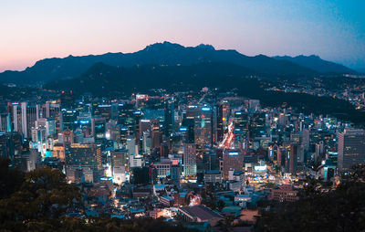 High angle view of illuminated buildings against sky at night