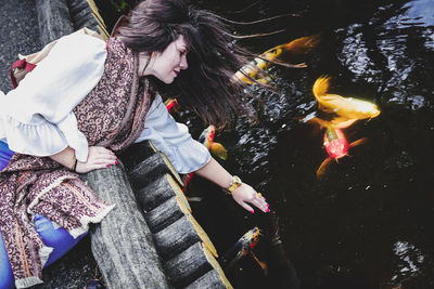 Beautiful girl next to koi fishes