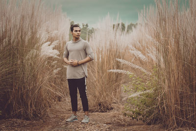 Portrait of young man standing on field