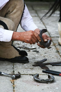 Low section of blacksmith holding horseshoe