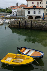 High angle view of boats moored in lake against buildings