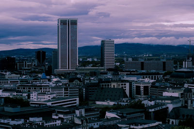 Modern buildings in city against sky during sunset