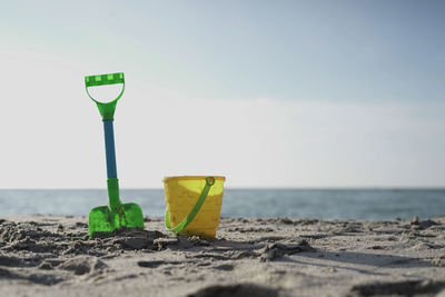 Toys on sand at beach against sky