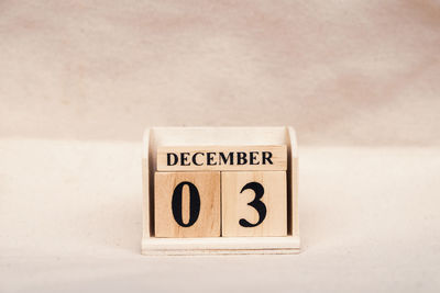 Close-up of information sign on table against wall