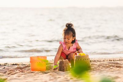 High angle view of girl playing on sand at beach