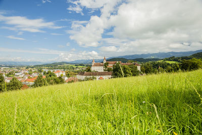 Buildings on field against sky