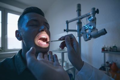 Cropped hand of doctor examining patients throat