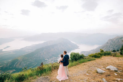 Rear view of woman on mountain against sky