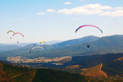 People paragliding above mountains