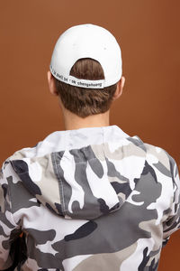 Rear view of boy standing against white background