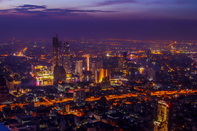 Aerial view of illuminated buildings in city at night