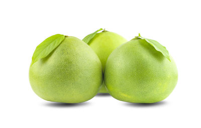 Close-up of green fruits against white background