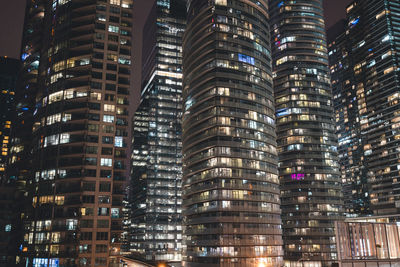 Low angle view of illuminated buildings in city at night