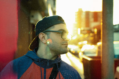 Portrait of young man looking away in city