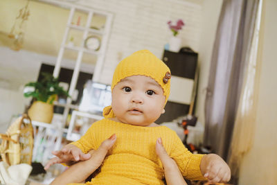 Portrait of cute baby girl sitting on floor