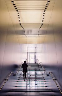 Rear view of woman moving up on staircase