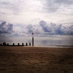 Scenic view of beach against cloudy sky