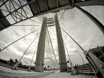 Low angle view of bridge against cloudy sky