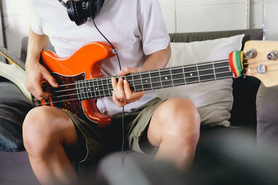 Midsection of man playing guitar