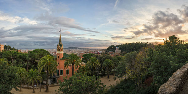 Panoramic view of trees and buildings against sky