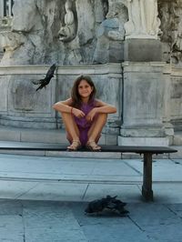 Portrait of young woman standing in front of wall