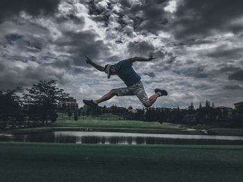Digital composite image of man jumping against sky