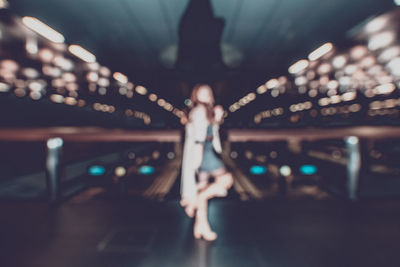 Midsection of woman in illuminated city at night