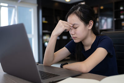 Teenage girl sitting on table