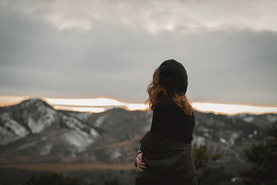 Woman standing on mountain against sky