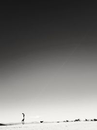 Man standing on beach against clear sky