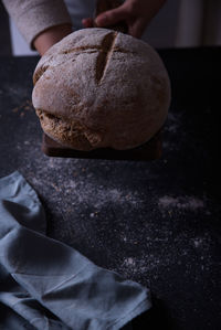 Hands putting freshly made bread on the table.