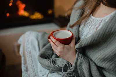 Midsection of woman holding coffee cup