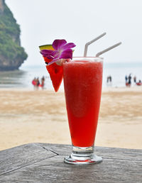 Close-up of watermelon juice on table against sea