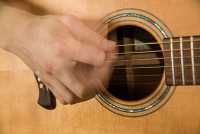 Cropped hand playing guitar