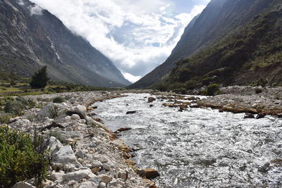 Scenic view of river and mountains against sky