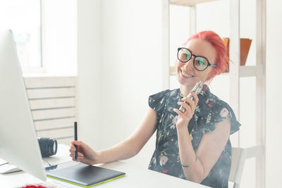 Red head woman smoking electronic cigarette at office