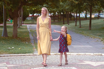 Portrait of woman standing on footpath