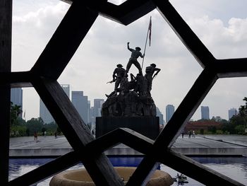 Low angle view of statue against sky in city