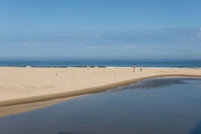 Scenic view of beach against blue sky