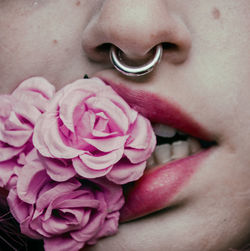 Cropped image of woman biting artificial rose