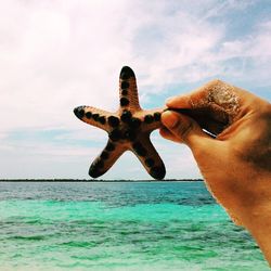 Cropped image of person standing by sea