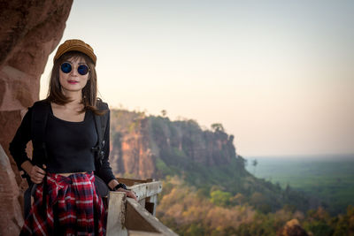 Young woman standing against sky during sunset