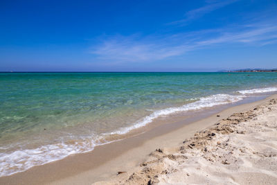 Scenic view of beach against blue sky