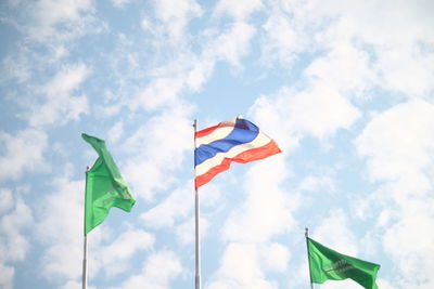 Low angle view of flags against cloudy sky