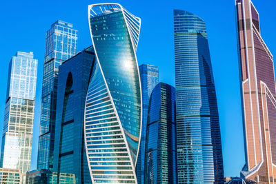 Low angle view of modern buildings against blue sky